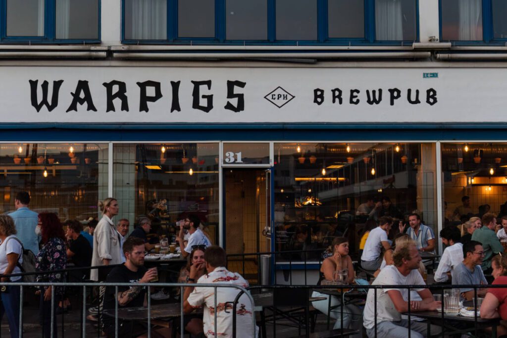 Copenhagen, Denmark. August 13, 2022. Warpigs Brewpub in Meatpacking District with people sitting on the terrace