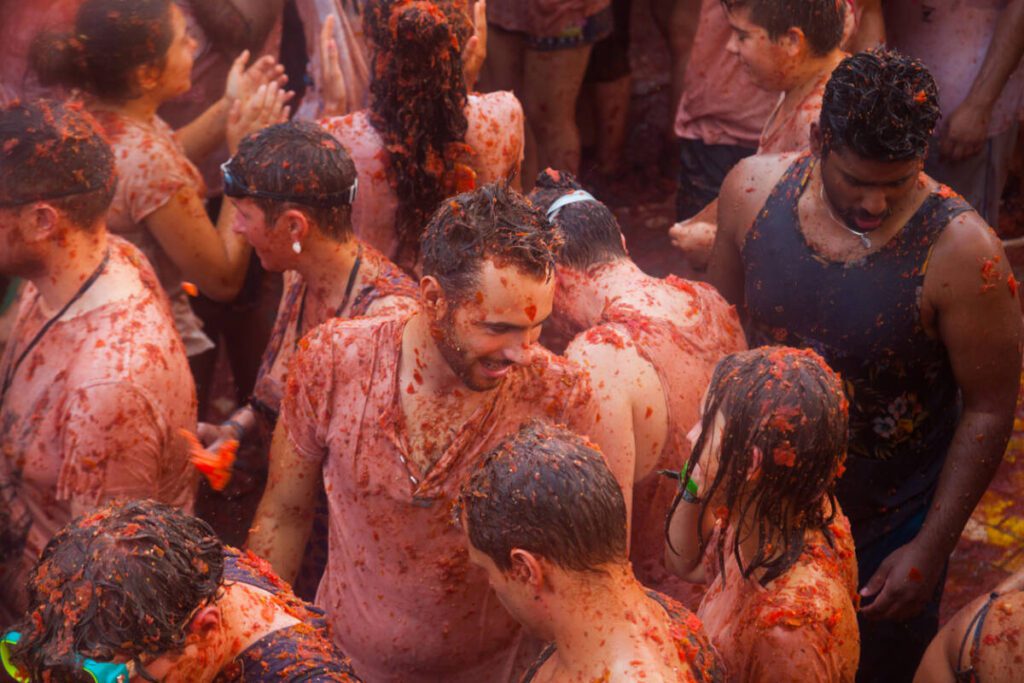 BUNOL, SPAIN - AUGUST 30, 2018: Battle of tomatoes. La Tomatina festival where people are fighting with tomatoes at street